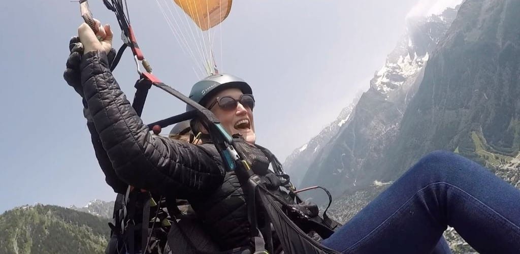 Photo of Change Coach Becky paragliding above mountains