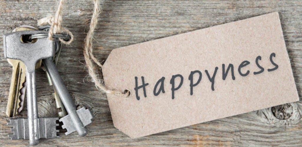 Photo of a bunch of keys on a table top with a label attached to them that reads 'Happyness'