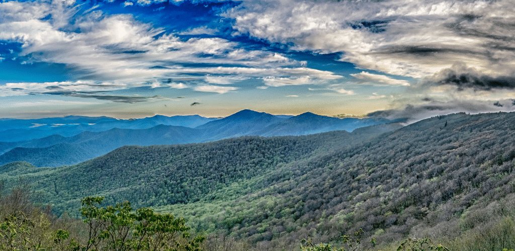 Image of rolling hillsides and a blue sky with fluffy clouds.